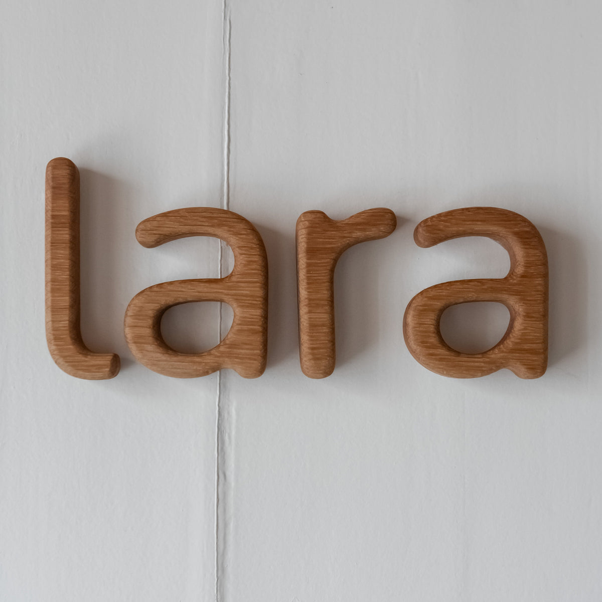 Naam LARA in eikenhout op de deur kinderkamer